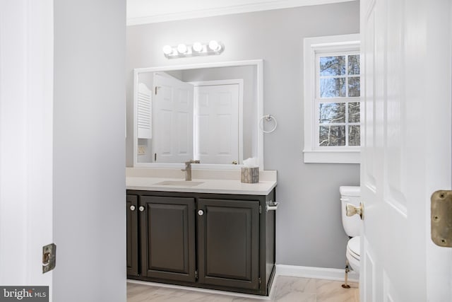 bathroom with vanity, crown molding, and toilet