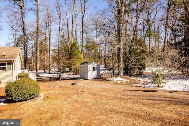 snowy yard with a storage shed