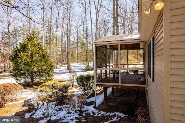 snow covered deck with a sunroom