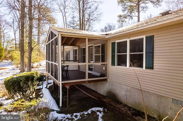 view of snowy exterior featuring a sunroom