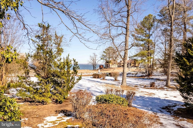 snowy yard featuring a water view