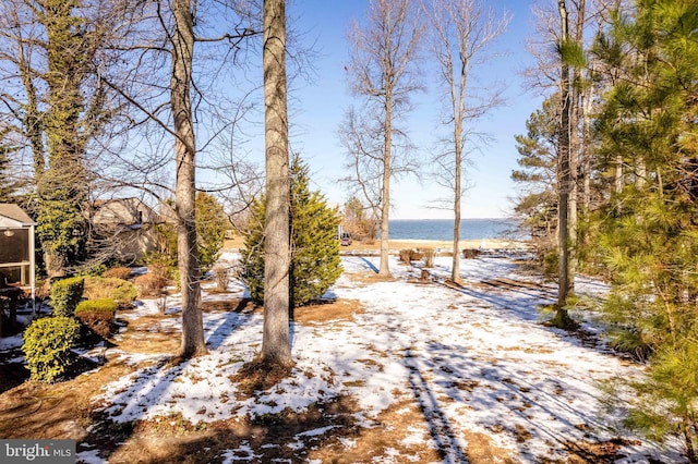 snowy yard featuring a water view