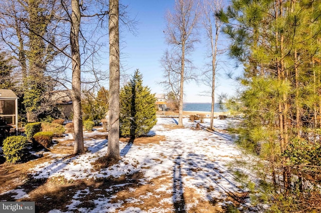 snowy yard featuring a water view