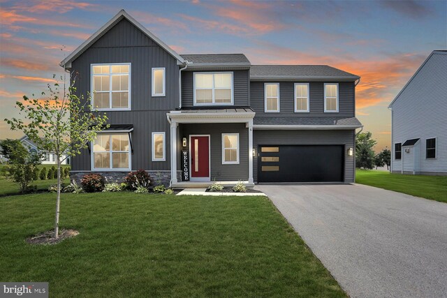 view of front of home with a garage and a yard