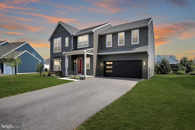 view of front of home with a garage and a yard