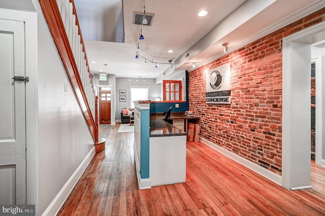 kitchen featuring brick wall and light hardwood / wood-style flooring