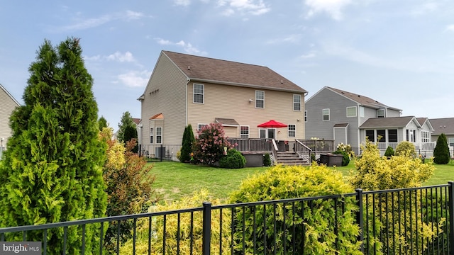 rear view of property with a wooden deck and a lawn