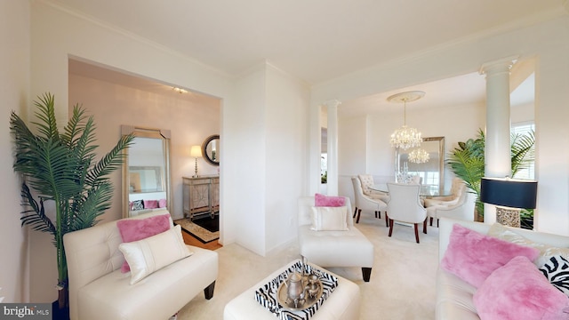 carpeted living room featuring crown molding, decorative columns, and a notable chandelier