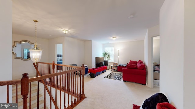 carpeted living room with a notable chandelier