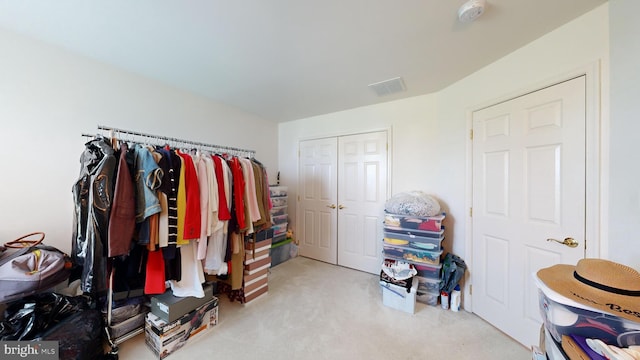 walk in closet featuring light colored carpet