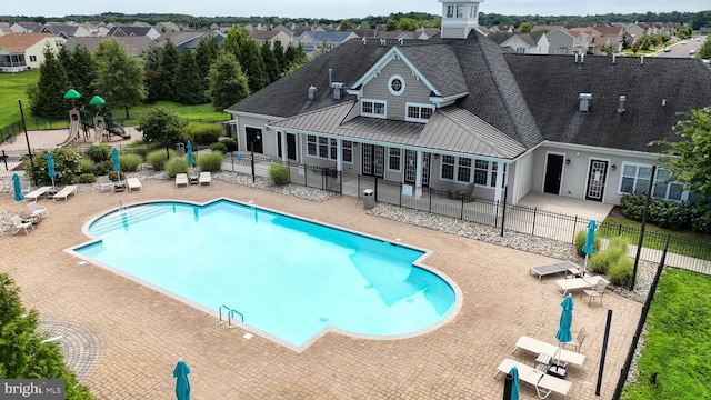 view of swimming pool with a playground and a patio