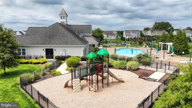 view of playground featuring a fenced in pool