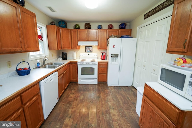 kitchen with dark hardwood / wood-style floors, white appliances, and sink