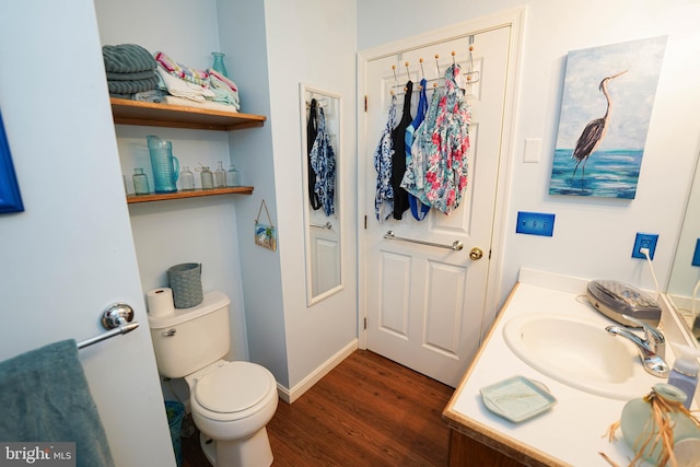 bathroom with vanity, toilet, and hardwood / wood-style floors