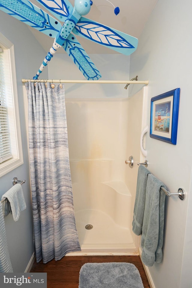 bathroom featuring wood-type flooring and a shower with curtain