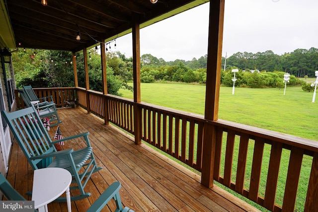 wooden deck featuring a lawn