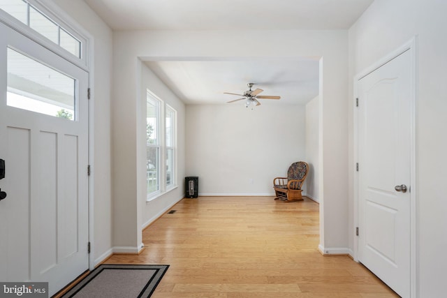 foyer entrance featuring light wood-style flooring, baseboards, and a ceiling fan