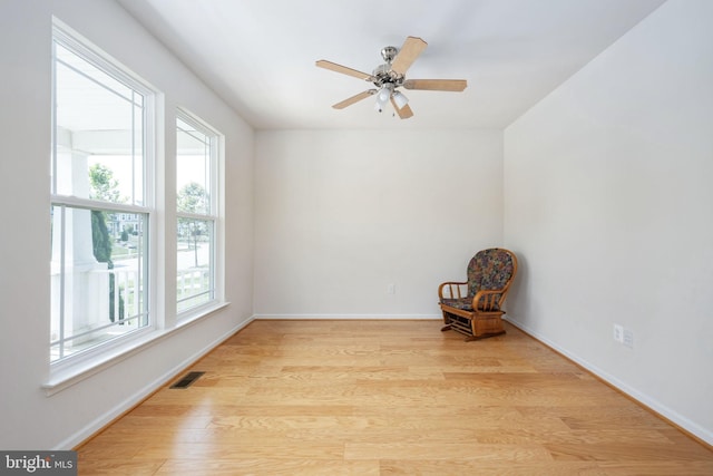 unfurnished room with light wood-style floors, visible vents, baseboards, and a ceiling fan