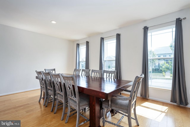 dining space featuring baseboards, a wealth of natural light, and light wood-style floors