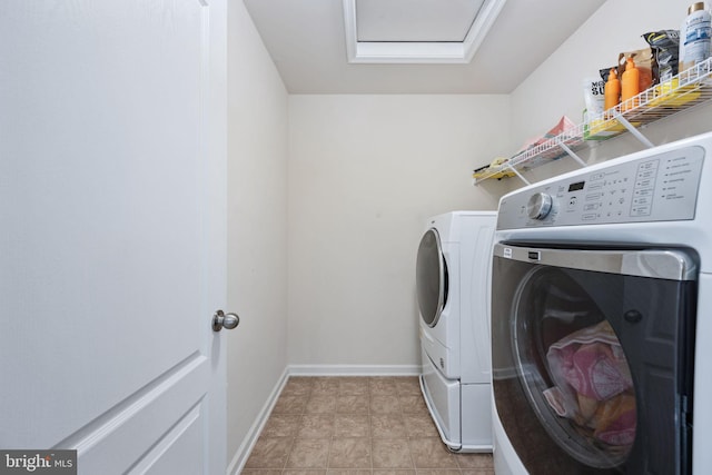 washroom with laundry area, washing machine and clothes dryer, attic access, and baseboards