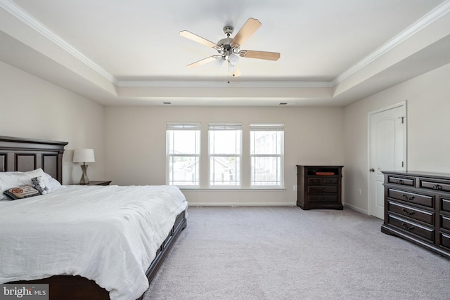 bedroom featuring a raised ceiling, light carpet, crown molding, and baseboards