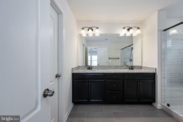 full bathroom with double vanity, a shower stall, a sink, and tile patterned floors