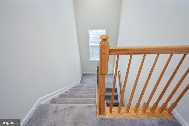 stairway featuring carpet and baseboards