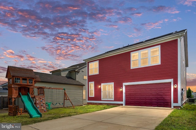 view of front facade featuring an attached garage, a playground, and concrete driveway