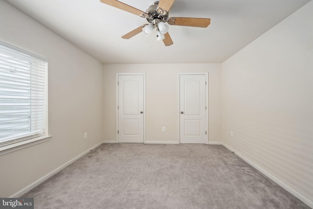 unfurnished bedroom with light carpet, ceiling fan, and baseboards