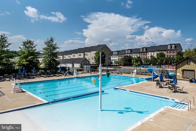 pool featuring a patio, fence, and a residential view