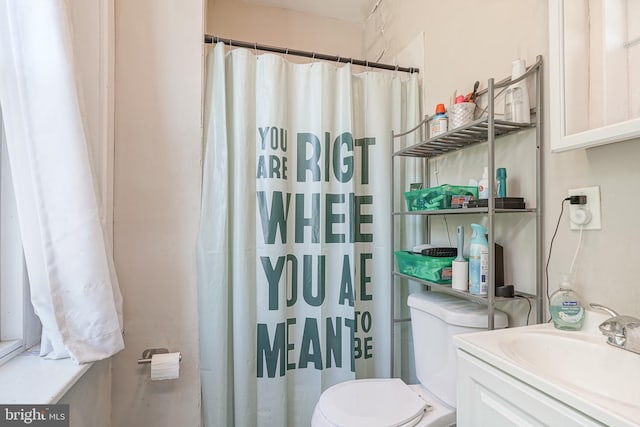 bathroom with vanity, curtained shower, and toilet