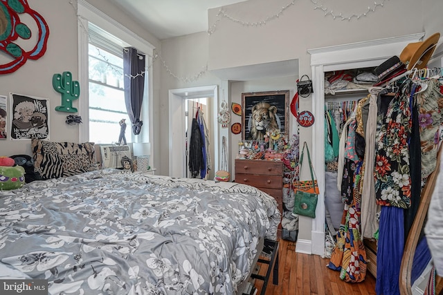 bedroom with dark wood-type flooring, a closet, and cooling unit