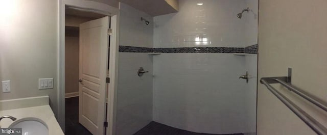 bathroom featuring a tile shower and vanity