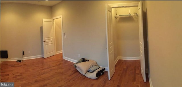 unfurnished bedroom featuring a closet, hardwood / wood-style floors, and a walk in closet