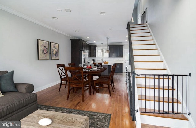 dining space featuring hardwood / wood-style flooring and crown molding