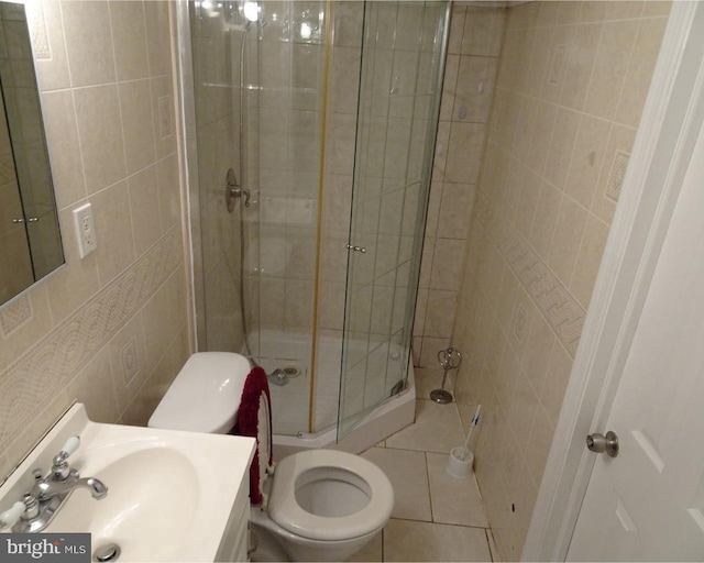 bathroom with tile patterned floors, walk in shower, sink, tile walls, and toilet