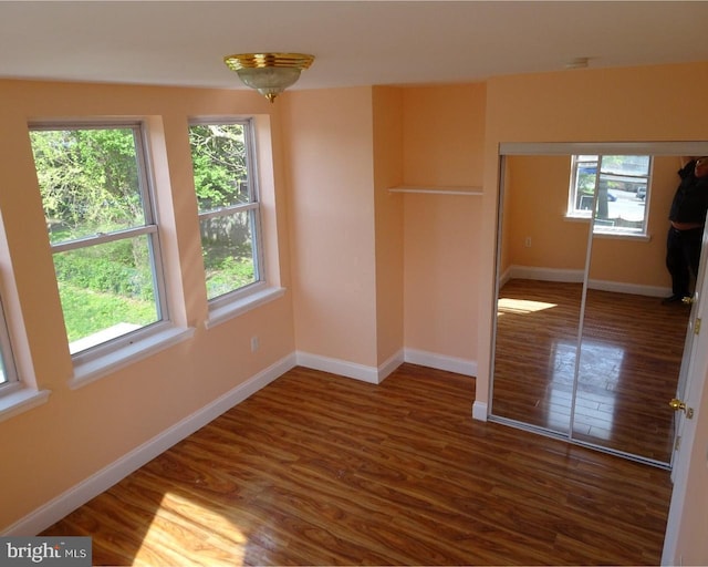 unfurnished bedroom featuring a closet and dark wood-type flooring