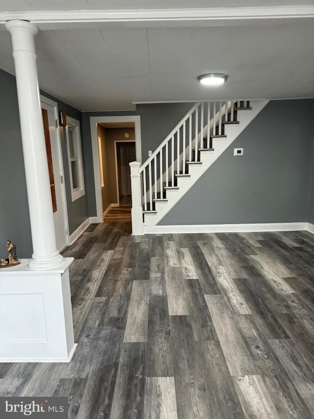 stairs featuring wood-type flooring and ornate columns