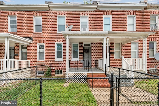 multi unit property with a porch and a front lawn