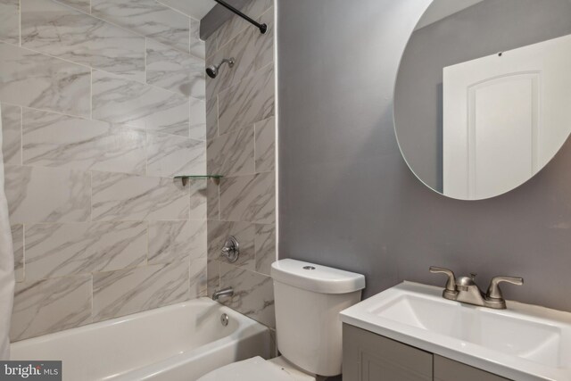 full bathroom with toilet, vanity, and tiled shower / bath