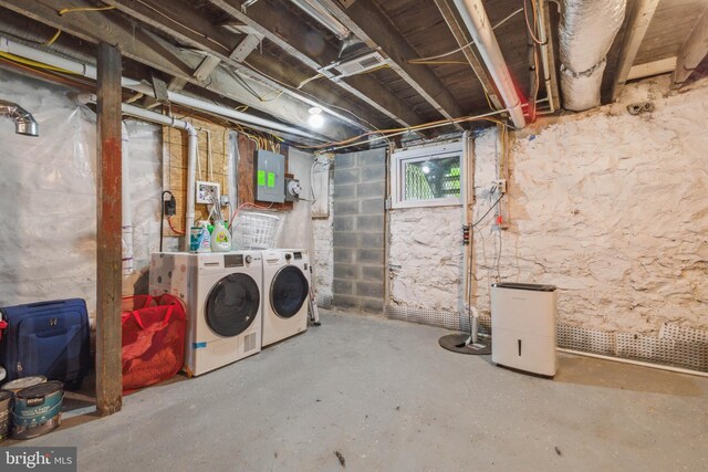 basement featuring electric panel and washer and clothes dryer