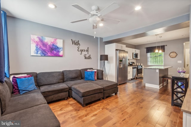 living room featuring ceiling fan and light wood-type flooring