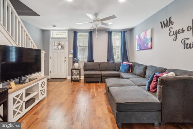 living room with light hardwood / wood-style floors and ceiling fan