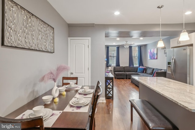 dining space with ceiling fan and hardwood / wood-style flooring