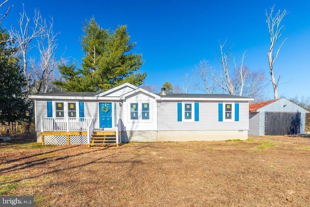 manufactured / mobile home featuring a shed and a front lawn