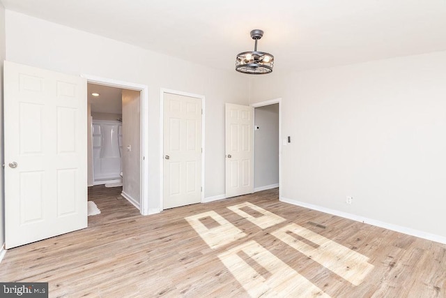 unfurnished bedroom featuring light hardwood / wood-style floors and a notable chandelier