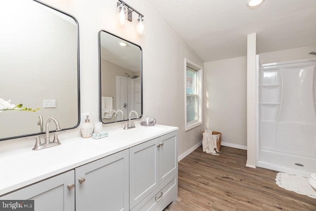 bathroom with vanity, a shower, wood-type flooring, and lofted ceiling