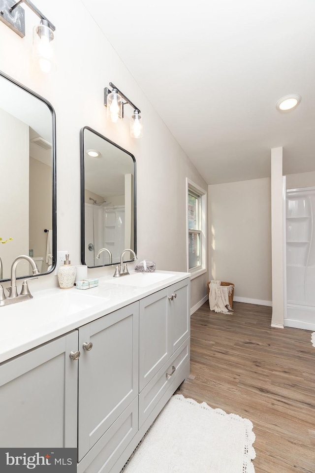 bathroom featuring vanity, hardwood / wood-style flooring, and lofted ceiling