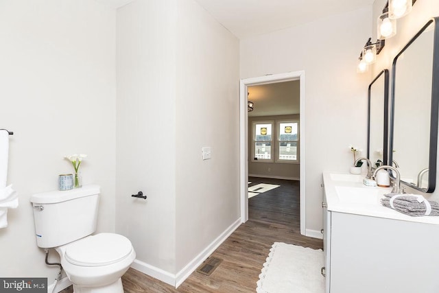 bathroom featuring wood-type flooring, vanity, and toilet