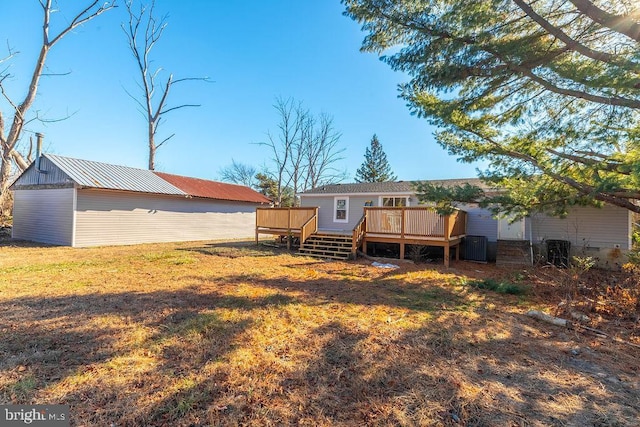 rear view of property featuring a wooden deck and a yard